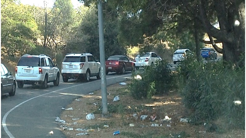 cars on off ramp with trash